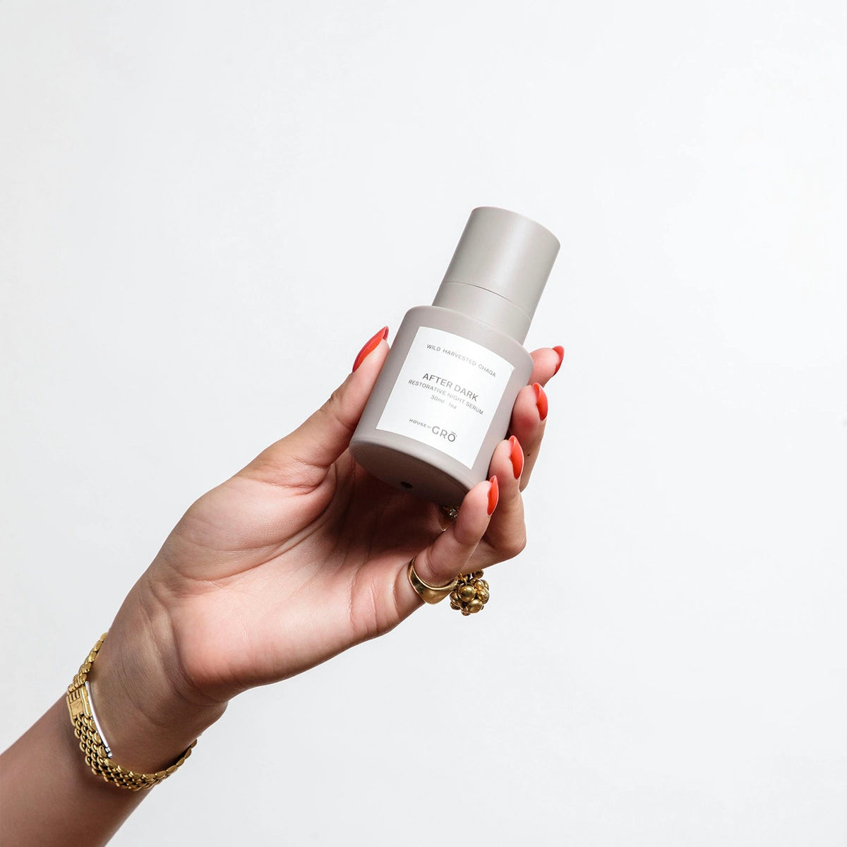 Hand holding the House of GRŌ After Dark Restorative Night Serum bottle, displaying its actual size and elegant packaging.