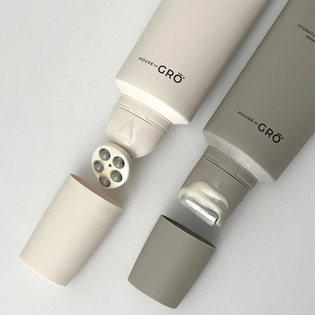 Close-up of the House of GRŌ Feel Relief Salve and Touch Body Serum, showing their unique massage applicators and soothing cream texture.