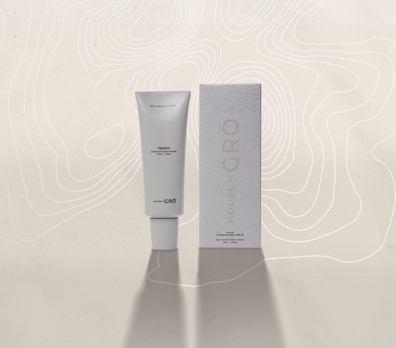 House of GRŌ Touch Hydrating Body Serum tube and its textured retail packaging box on a light background.