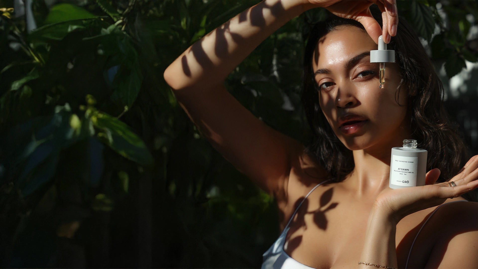 Woman applying mushroom-powered skincare serum with a dropper for naturally radiant, hydrated skin.